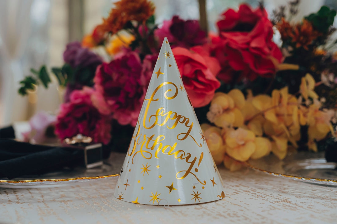 Party hat with happy birthday message and flowers